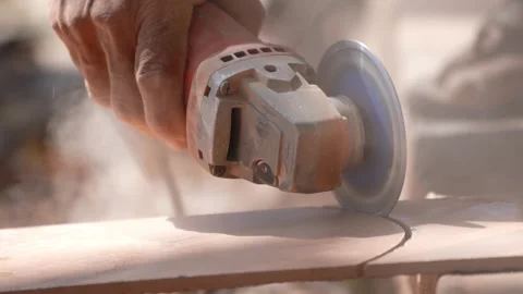 Close-up of a hand using an angle grinder to cut metal, sparks blurred in warm l Stock-Footage 333330493