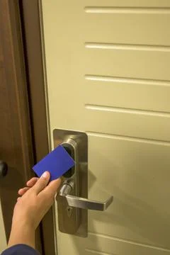 Close-up of a hand using a blue card key on a hotel door lock, key electronic Stock Photos