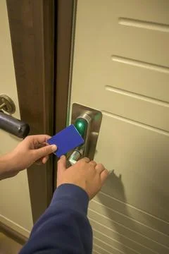 Close-up of a hand using a blue card key on a hotel door lock, key electronic Stock Photos