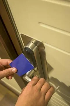 Close-up of a hand using a blue card key on a hotel door lock, key electronic Stock Photos