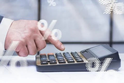 Close up hand using calculator with percentage symbol overlay representing in Stock Photos