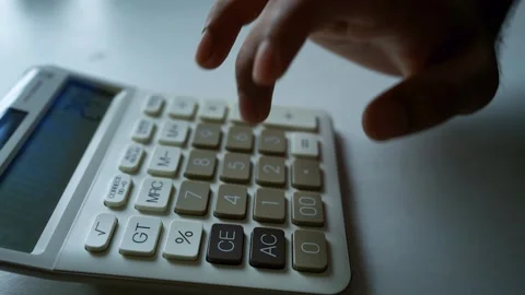 Close-up of a hand using a calculator on a white surface Stock Footage 318056914