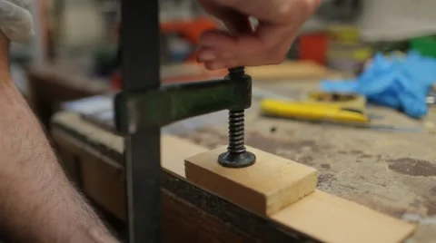 Close up on hand using clamp on wood, closing Stockbeeldmateriaal 60960650