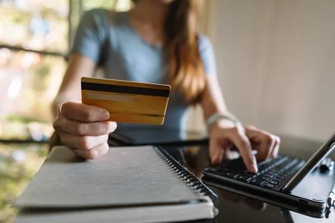 Close up of Hand using credit card and smartphone, laptop computer on wooden Stock Photos