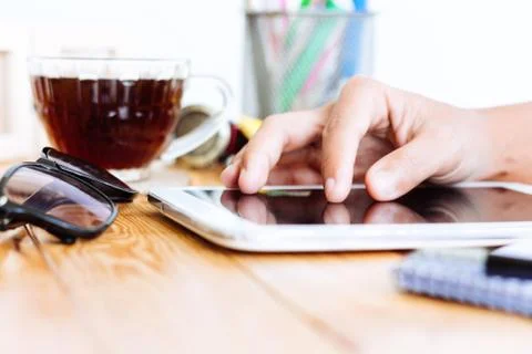 Close up hand using digital tablet on wood workspace Stock Photos