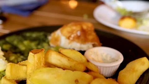 Close Up of Hand Using Fork to Eat Fish and Chips Stock Footage 329090523