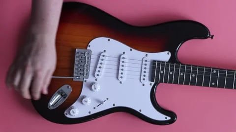 Close-up of a hand using a hex wrench to adjust an electric guitar bridge Stock Footage 339190851