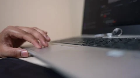 Close-up of a hand using a laptop touchpad, blurred screen in background Stock Footage 317131693