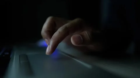 Close-up of a hand using a laptop touchpad in dim lighting Stock Footage 318578183