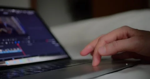 Close-up of hand using laptop touchpad to edit video footage on... Stock Footage 319881771