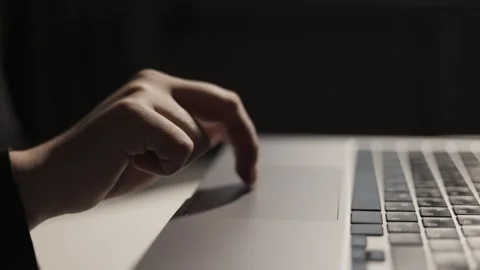 Close-up of a hand using a laptop touchpad with a dark background Stock Footage 339173725