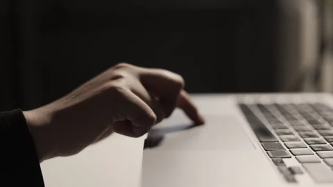 Close-up of a hand using a laptop touchpad in a dimly lit environment Stock Footage 339173814