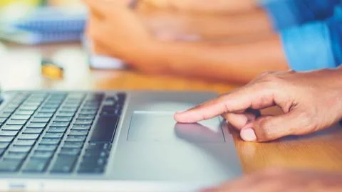 Close up of a hand using a laptop touchpad Stock Photos