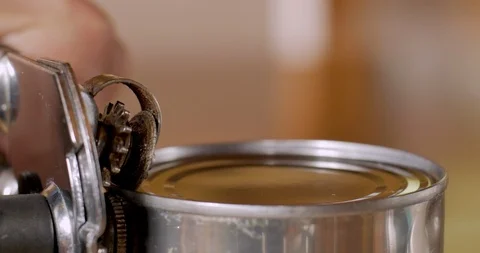 Close up of a hand using a manual can opener to open a can of food Stock Footage 92736065