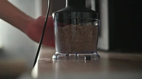 A close-up of a hand using a mixer to grind walnuts. The process takes place on 스톡 동영상 336778719