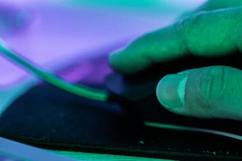 Close-up of a hand using a mouse - cyberpunk Stock Photos