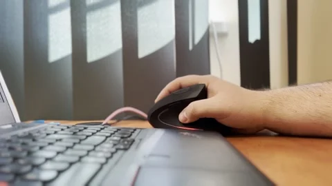 Close up hand using mouse with laptop computer, working late at night in warm Stock Footage 305252932