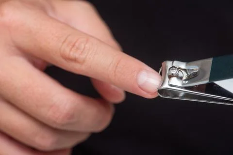 Close-up of a hand using nail clippers to trim fingernails Stock Photos