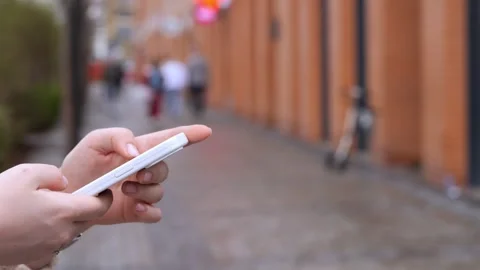 Close-up of hand using phone on city street Stock Footage 343854715
