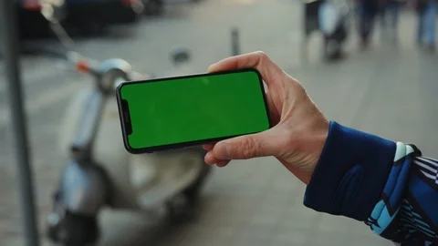 Close up hand using phone with horizontal green screen background motorcycle Stock Footage 117953316