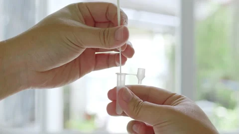 Close up hand using rapid antigen test kit (ATK) for self test at home Stock Footage 196903755