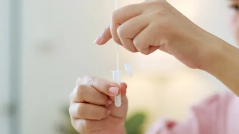 Close up hand using rapid antigen test kit (ATK) for self test at home Stock Footage 196910260
