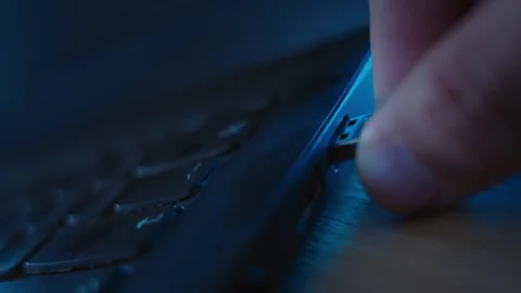 Close up on hand using small flash drive or thumb drive to install spyware app Video stock 334734277