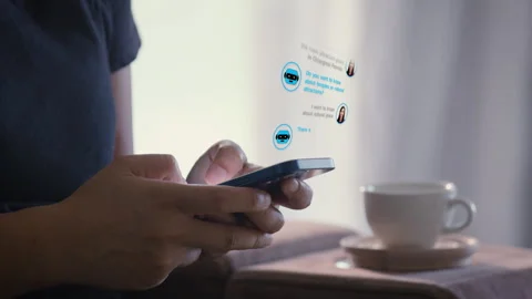 Close-up on hand using smart phone with the help of the chatbot at home. Видео 343954258