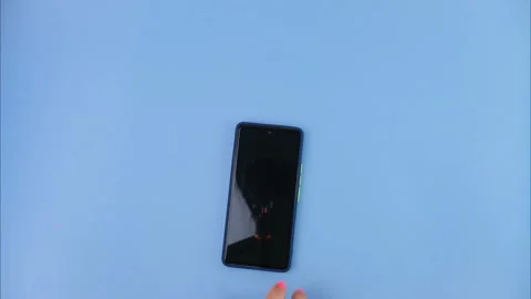 Close up of hand using smartphone on blue background. Stock Footage 251411313