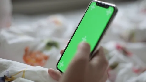Close up of hand using a smartphone with green screen display indoors. The girl  Stock Footage 96914409