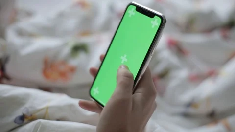Close up of hand using a smartphone with green screen display indoors. The girl  Stock Footage 96914499