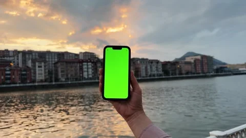 Close-up of a hand using a smartphone on river and buildings background. Chroma Stock Footage 303506159