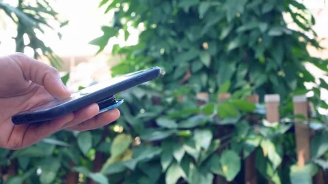 Close up hand using  smartphone tin the garden. Stock-Footage 123102926