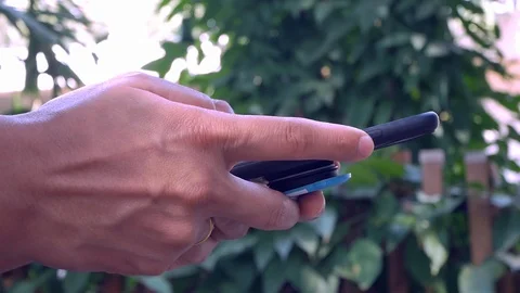 Close up hand using  smartphone tin the garden. Stock-Footage 123102985