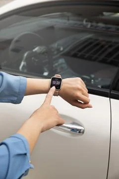 Close up hand using smartwatch to lock car Photo Stock Photos