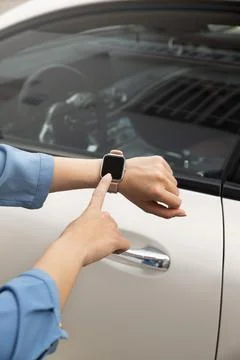 Close up hand using smartwatch to unlock car Photo Stock Photos