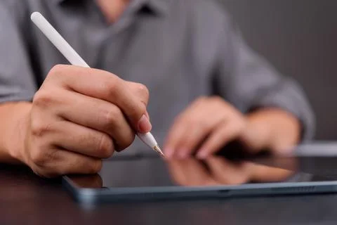Close-up of hand using stylus on digital tablet, representing e-signature, .. 스톡 사진