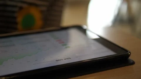 Close-Up Hand Using Tablet with Financial Graphs on Screen Stock Footage 322007161