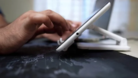 Close-up of a hand using a tablet on a stand, blurred background Stock Footage 318056741