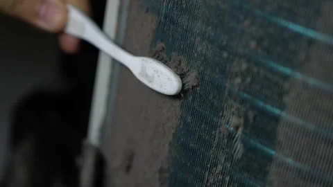 Close-up of a hand using a toothbrush to scrub thick dust from an air condi.. Stock Footage 338319396