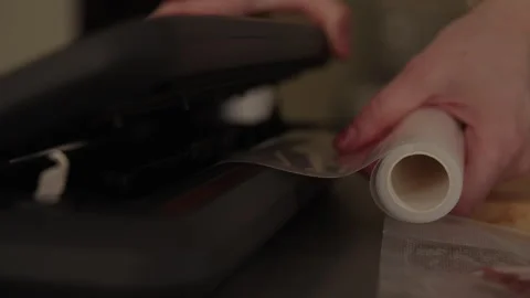 Close-up of hand using vacuum sealer, sealing plastic bag. Female chef feeding Stock Footage 313300204