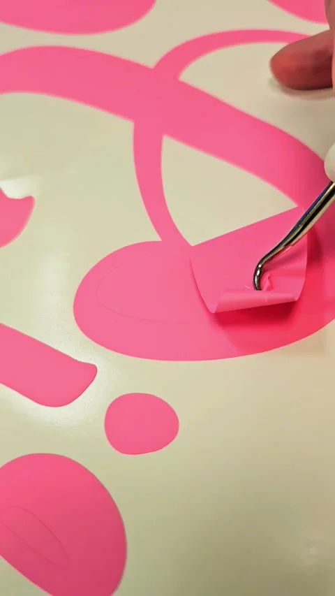 Close up of hand using weeding tool to peel pink vinyl sticker Stock Footage 346134578