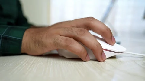 Close-up of a hand using a white computer mouse on a wooden desk Stock Footage 316902047