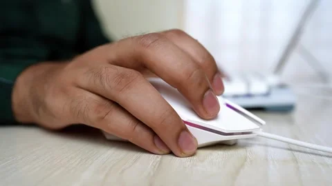 Close-up of a hand using a white computer mouse on a wooden desk Stock Footage 318056579