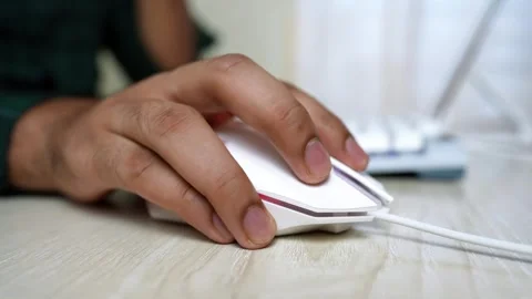 Close-up of a hand using a white computer mouse on a wooden desk Stock Footage 318056586