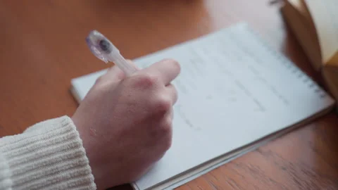 Close up hand view of fair skin person writing on white notebook Stock Footage 310752248