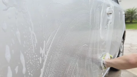 Close-up of a hand washing a silver car with a sponge and foam. Stock Footage 313299778