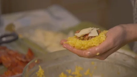 Close up of hand of while preparing Italian arancini with ham, peas and salam Stock Footage 125799350