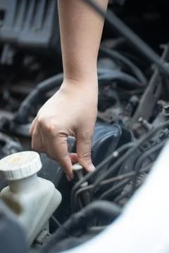 Close up of a  hand of woman pulling an engine oil dipstick to inspect oil .. Stock Photos