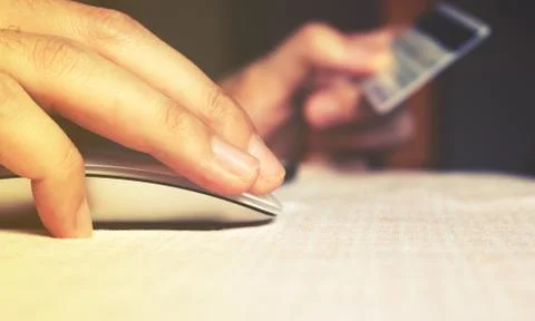 Close up hand woman using mouse for click login password with credit card. Stock Photos